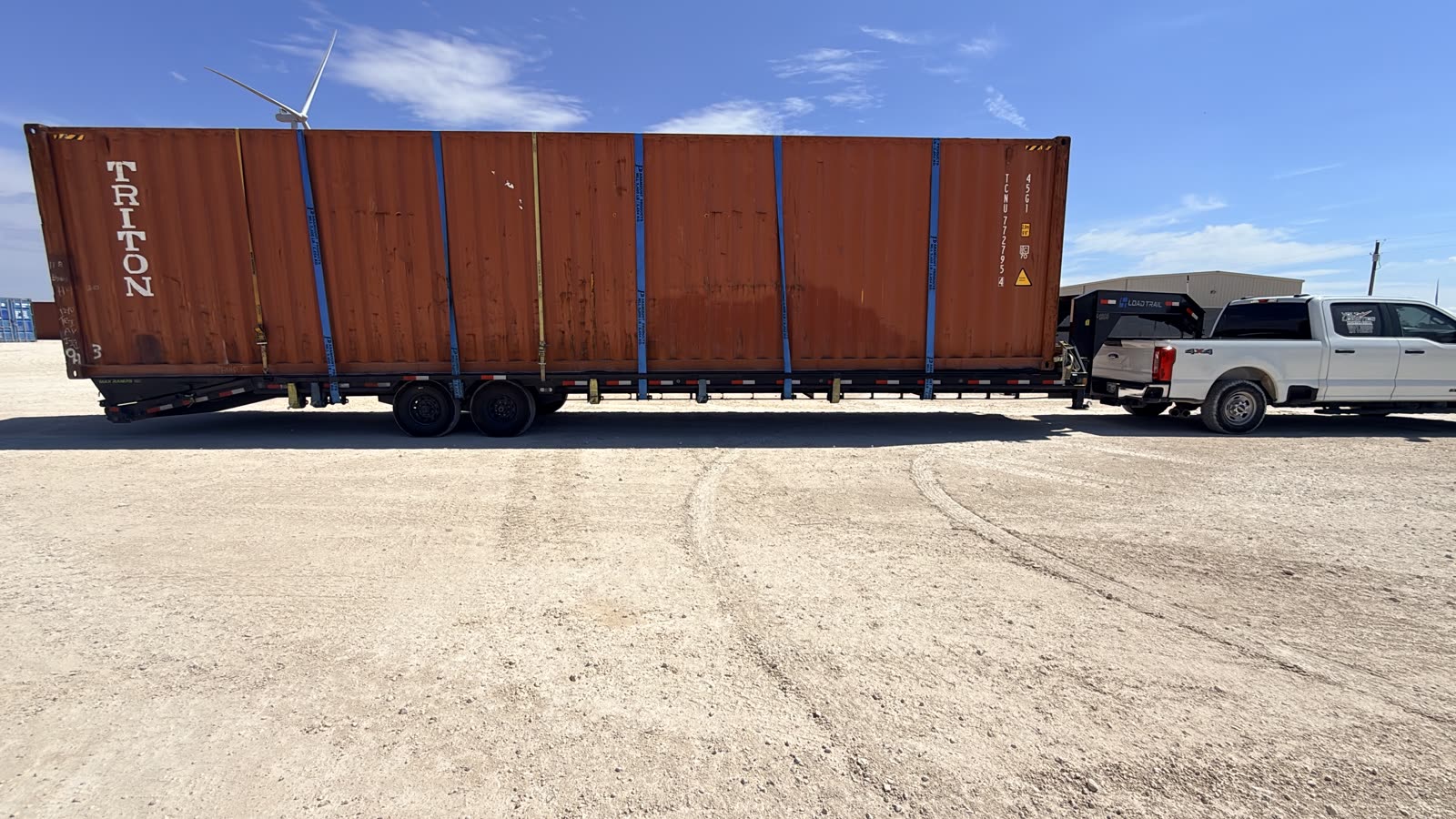 A Route 713 hotshot rig — a heavy-duty pickup pulling a gooseneck trailer loaded with a shipping container